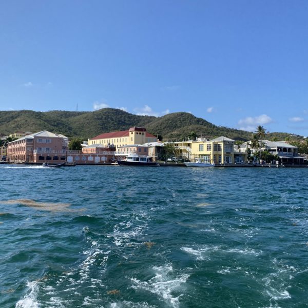 Coastline of large pastel buildings in front of hills