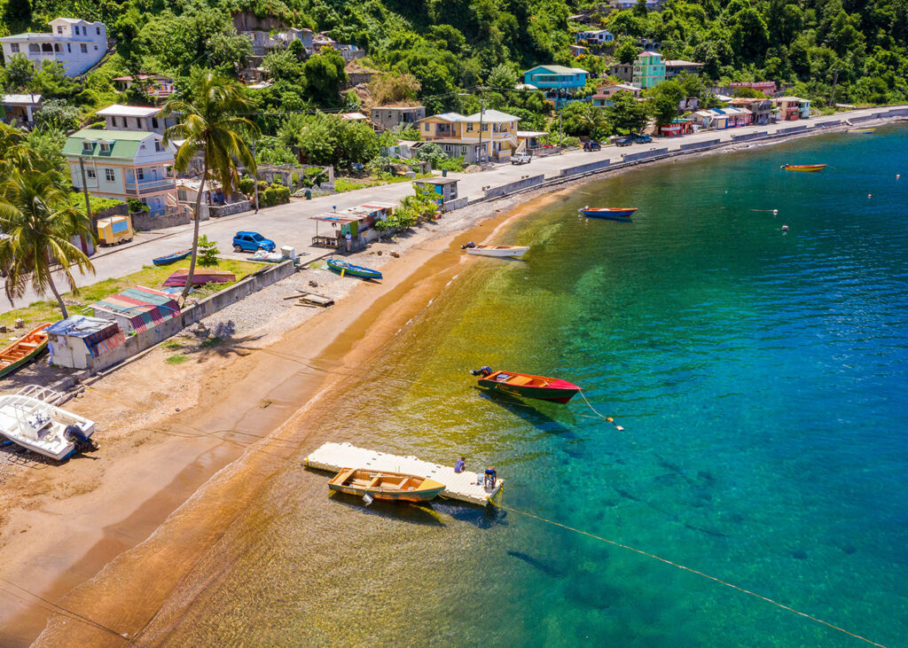 Shoreline next to a road with boats in the water