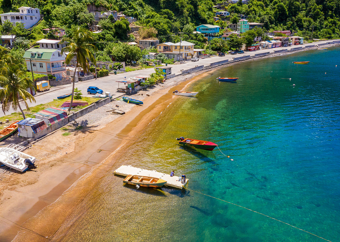 Shoreline next to a road with boats in the water